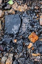 Background from natural cracked stones, layered black stone and iridescent sandstone close-up