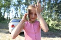 On the background of nature a little girl emotionally talking on the phone