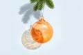 Background for New Year or Merry Christmas. Orange transparent round ball hanging on pine branch Royalty Free Stock Photo