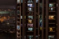 Background with night life in big city - modern high-rise building with windows of cozy apartments in which light shines