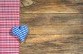 Background for Oktoberfest, blue bavarian heart and red rustic checkered fabric on wood.