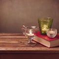 Background with old book and candles on wooden table Royalty Free Stock Photo