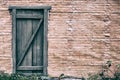 Background of an old brick wall with a wooden door, copy space. The texture of the door from wooden boards and red bricks Royalty Free Stock Photo