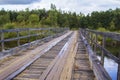 Background old destroyed bridge of planks and iron through forest River Royalty Free Stock Photo