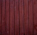 Background of old fence boards with red paint cracked from time to time. Close-up on weather-peeled boards with red Royalty Free Stock Photo