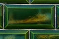 Background of old green tiles with cracks and iridescent tints Royalty Free Stock Photo