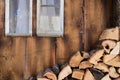 Background of an old romantic weathered wooden wall with an old window, a cord with bells in front of it and firewood