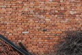 Background of old vintage orange brick wall with dry branches and roof tiles. Royalty Free Stock Photo