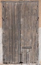 Background of an old weathered closed wooden door that is in portrait format in an old wall Royalty Free Stock Photo