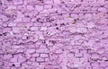 Old and worn brick wall painted in purple