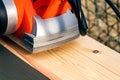 Background with an orange electric plane on the processed surface of a wooden beam Royalty Free Stock Photo