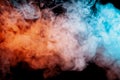 Background of orange, purple, red and blue wavy smoke on a black isolated ground. Abstract pattern of steam from vape of smoothly Royalty Free Stock Photo