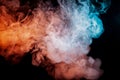 Background of orange, purple, red and blue wavy smoke on a black isolated ground. Abstract pattern of steam from vape of smoothly Royalty Free Stock Photo