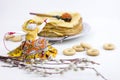 Background with pancakes, textile doll, sushki, pussy-willow and spoon with caviar on white for Maslenitsa festival.