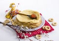 Background with pancakes, textile doll, sushki, pussy-willow and spoon with caviar on white for Maslenitsa festival.