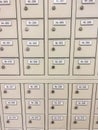 A background pattern of numerous beige post office boxes or mail lockers with numbers and key locks. Royalty Free Stock Photo