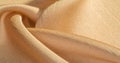 Background, pattern, texture, beige golden silk fabric It has a smooth matte finish and is durable due to a slightly twisted yarn.