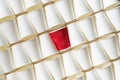 Background pattern of white paper cups with red cup in the middle