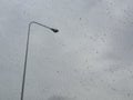 Background picture of rain drops on the car' s window with a street lamp in rainy day Royalty Free Stock Photo