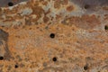 background of a piece of iron with even small holes, slightly corroded by rust.