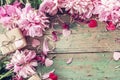 Background with pink peonies, gift box and hearts on old green b Royalty Free Stock Photo