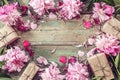 Background with pink peonies and gift box on old green boards. Royalty Free Stock Photo