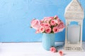 Background with pink roses flowers in blue cup and white lanter Royalty Free Stock Photo