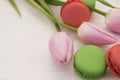 Background with pink tulips and macaroons.