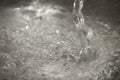 Background from the pouring water with bubbles in the metal sink, macro Royalty Free Stock Photo
