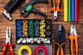 Background of professional electrician tools: cable lugs in the organizer box, insulating tape, earplugs, cutters, tips, burnerpul Royalty Free Stock Photo