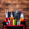 Background of professional electrician tools in the pockets of a loincloth on a wooden background Royalty Free Stock Photo