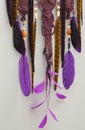 Background of purple dreamcatcher macrame feathers on gray wall