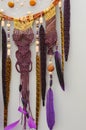 Background of purple dreamcatcher macrame feathers on gray wall