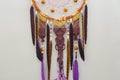 Background of purple dreamcatcher macrame feathers on gray wall