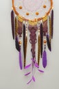Background of purple dreamcatcher macrame feathers on gray wall