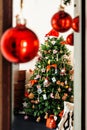 On a background of red balls decorated Christmas tree is visible Royalty Free Stock Photo