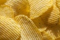 Background of ridged potato chips with spices. Closeup