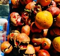 Background of ripe torn pomegranates and an orange in the oriental market. Fruit prepared for making freshly squeezed juice