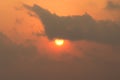 Background of rising sun behind cloudy.