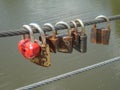 On the background of the river hang old, rusty locks & red lock - Heart Royalty Free Stock Photo