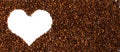 Background of roasted coffee beans. Space for text in the shape of a heart