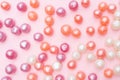 Background of round candies in glaze. Candy pearls. White, orange and purple. Pink Background. Flat lay. Top view