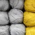 background of rows skeins of fluffy wool yarn for knitting soft gray and yellow colors. square.