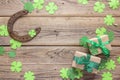 Background with rusty horseshoe, clover leaves and gift boxes on