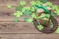 Background with rusty horseshoe, clover leaves and gift boxes on