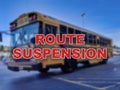 Blurred background of a school bus with the words Route Suspension in the foreground