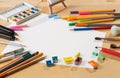 Background with a set of watercolor paints, pencils, brushes and sheets of paper on a wooden table Royalty Free Stock Photo