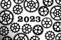 2023 on a background with silhouettes of gears on a white background.Concept progress and movement