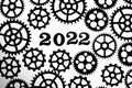 2022 on a background with silhouettes of gears on a white background.Concept progress and movement