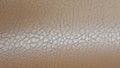 Shiny beige leather background close-up. Beige Glossy Texture Of Artificial Leather. Royalty Free Stock Photo